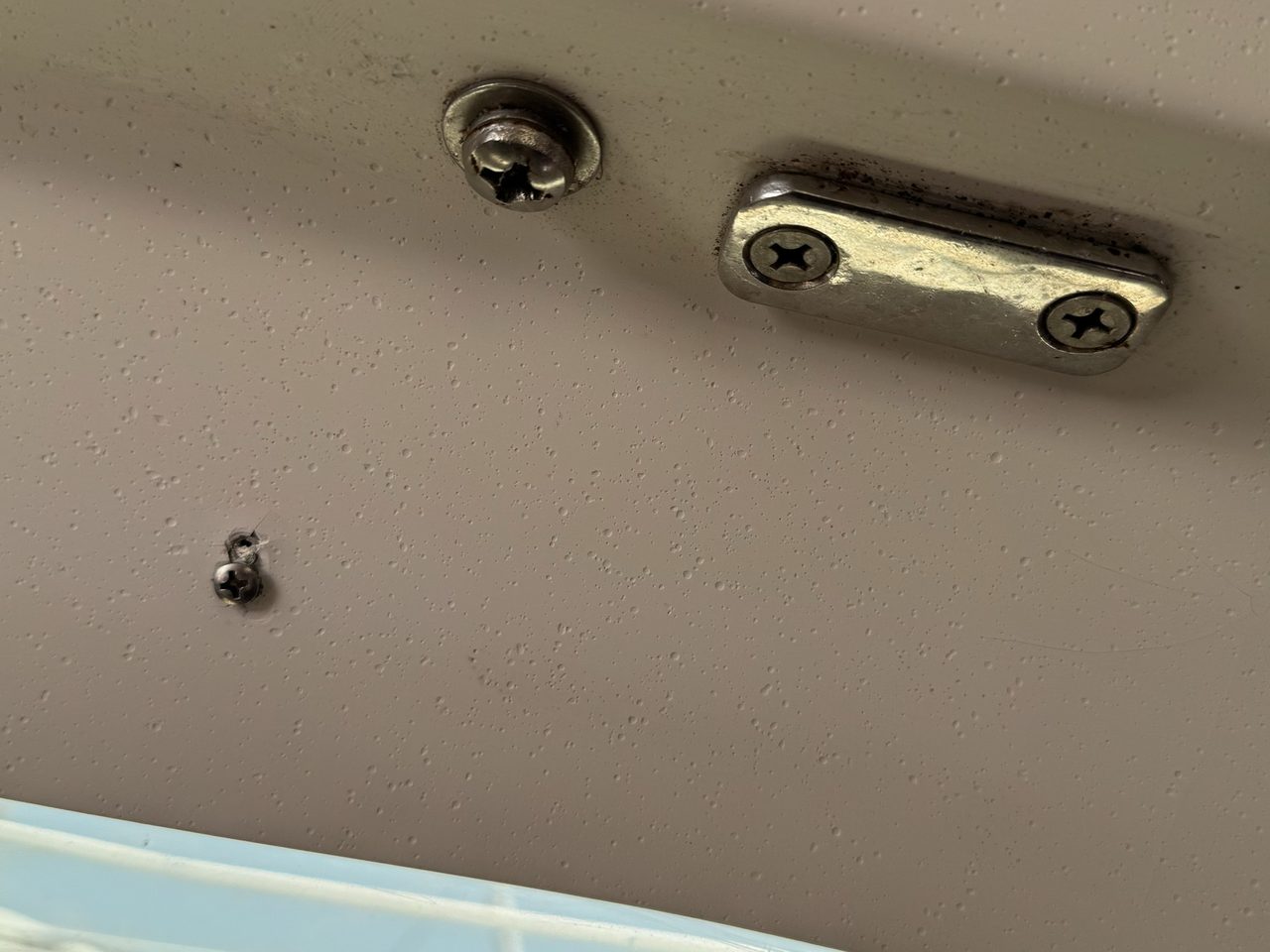 Inside, looking up. The plate with the staining, a handrail bolt to its left, and the portlight at bottom left.