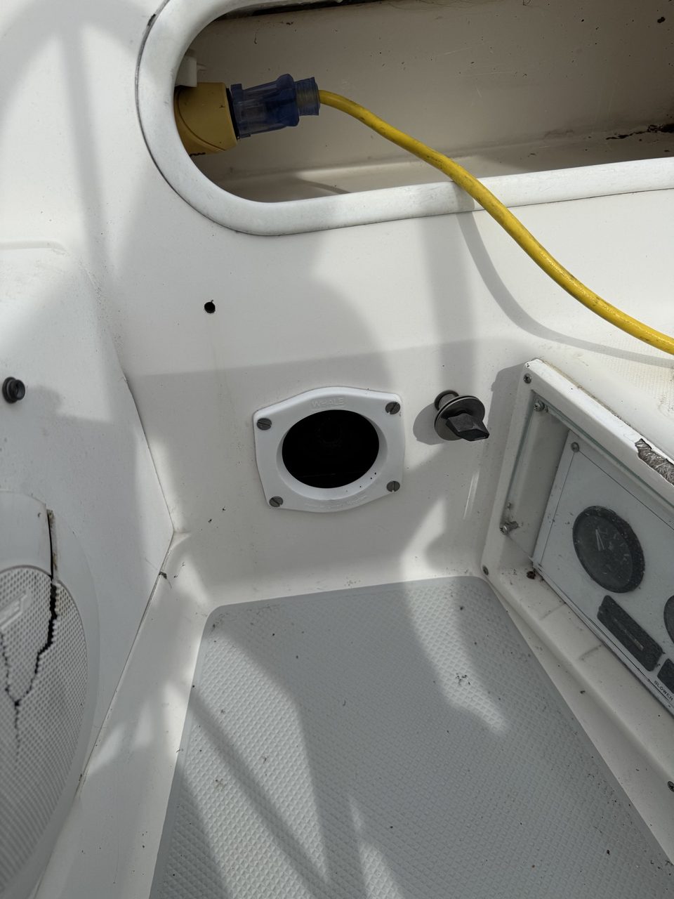 The port-aft cockpit recess with the original inlet removed. The yellow domestic extension cord and blue adapter were the old shore-power arrangement.
