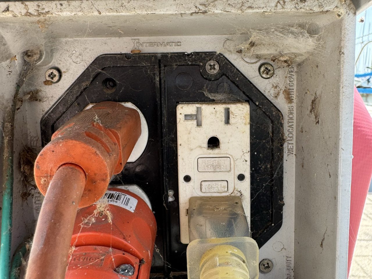 A weatherproof outlet box on the dock pedestal with two cords plugged into a GFCI receptacle
