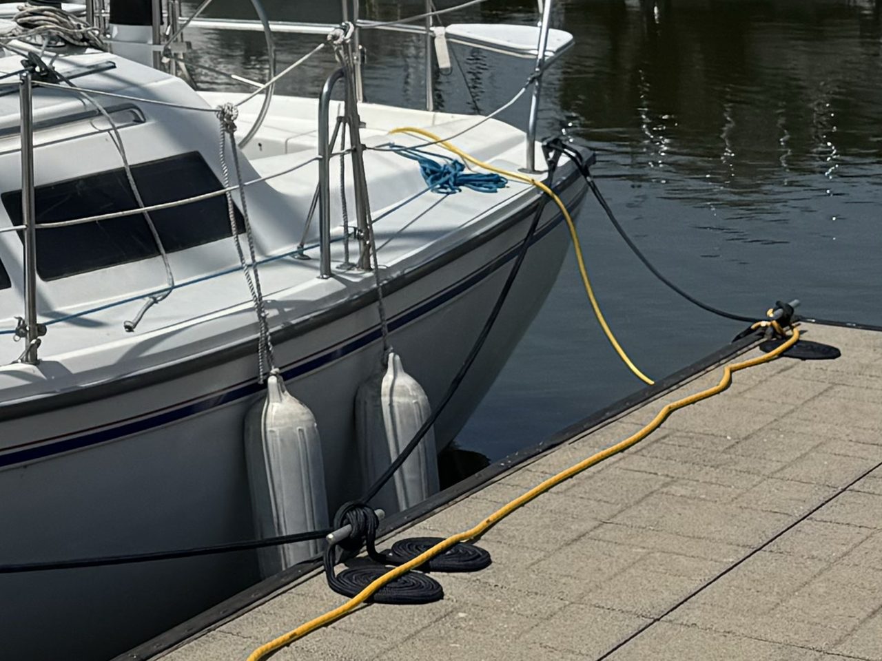Swallow's port quarter, the white topsides above the blue stripe bare and unlettered