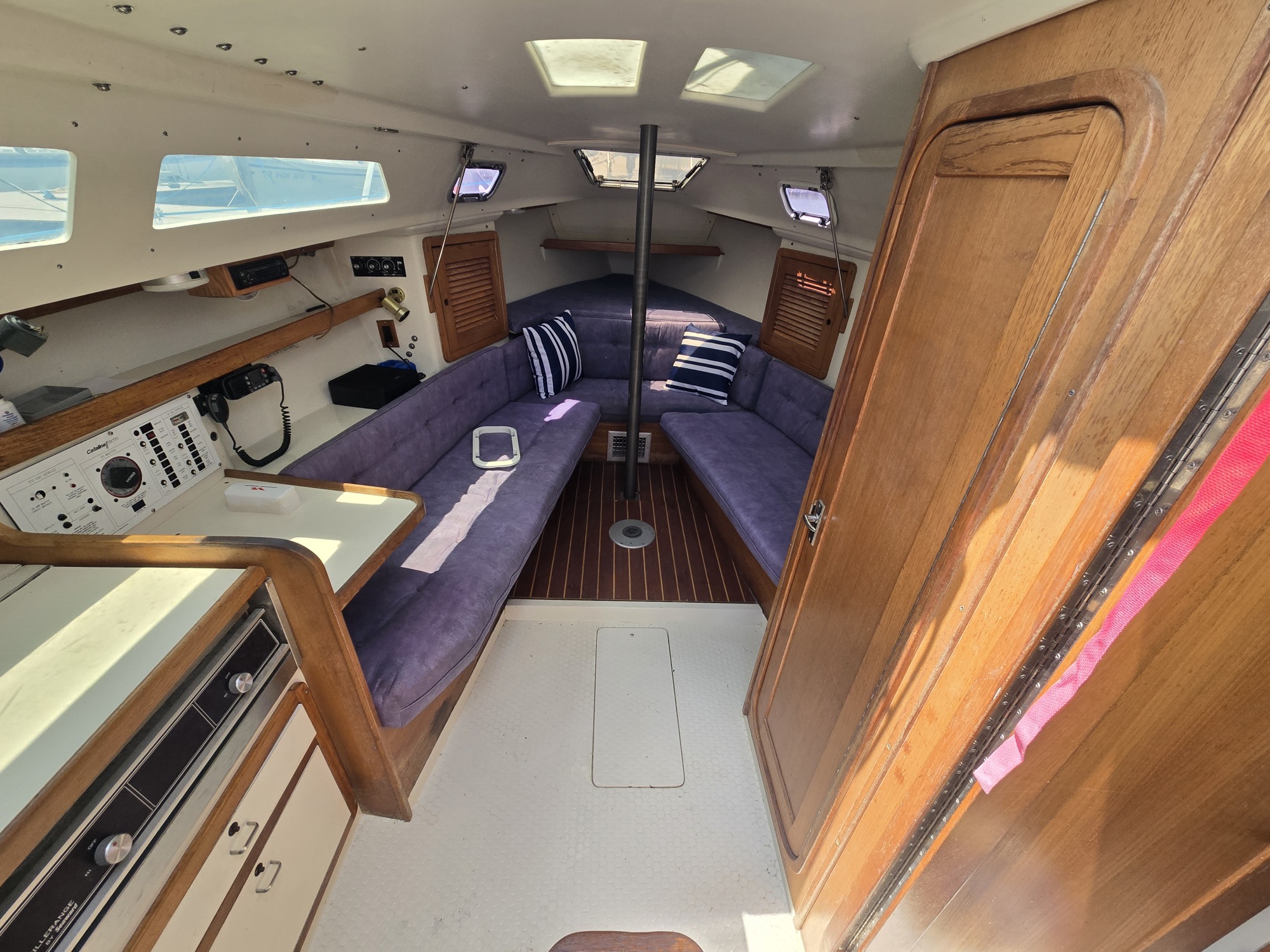 Saloon looking forward. Settees either side, galley to port, V-berth beyond the bulkhead.