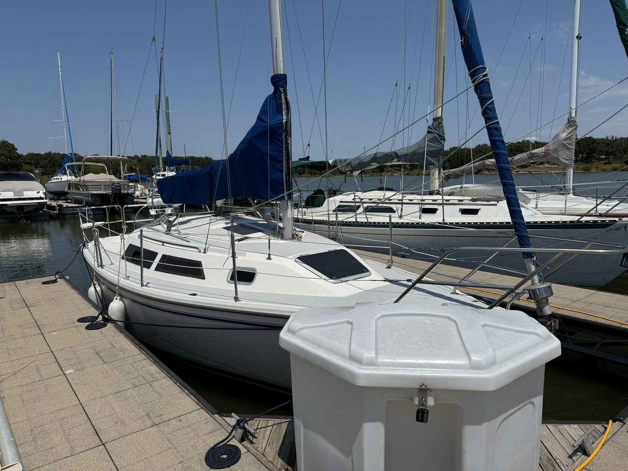 Swallow lying in her new slip, with a large white dock box on the corner of the finger in the foreground